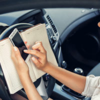 Woman working while driving.jpg.crdownload